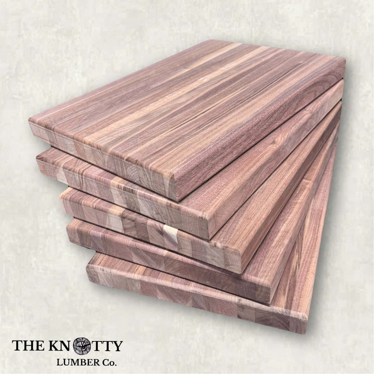 Set of wooden cutting boards with visible grain pattern on a light background, branded 'The Knotty Lumber Co'.