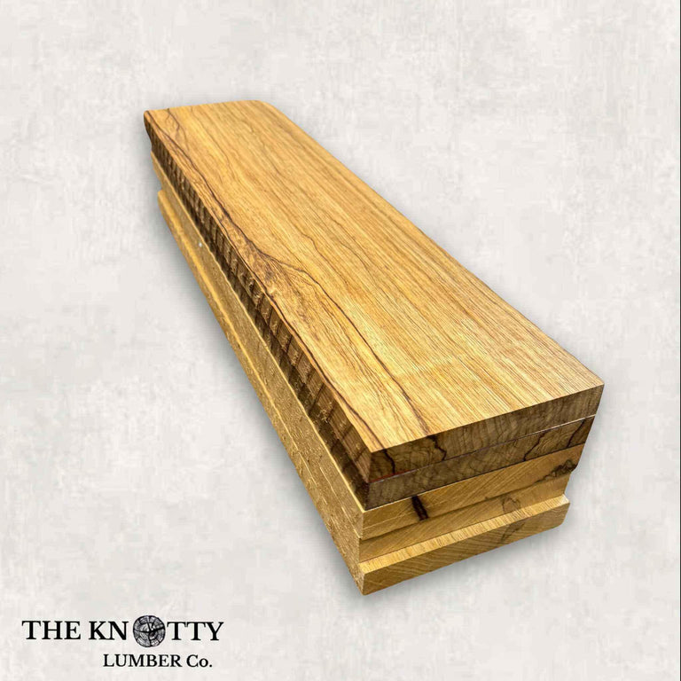 A lumber pack of Black Limba wood, showing the wood grain and some dark streaks, branded by The Knotty Lumber Co.