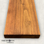 Black Walnut 4/4 hardwood image. A Wooden board with the grain and with 'The Knotty Lumber Co.' logo on a light gray background