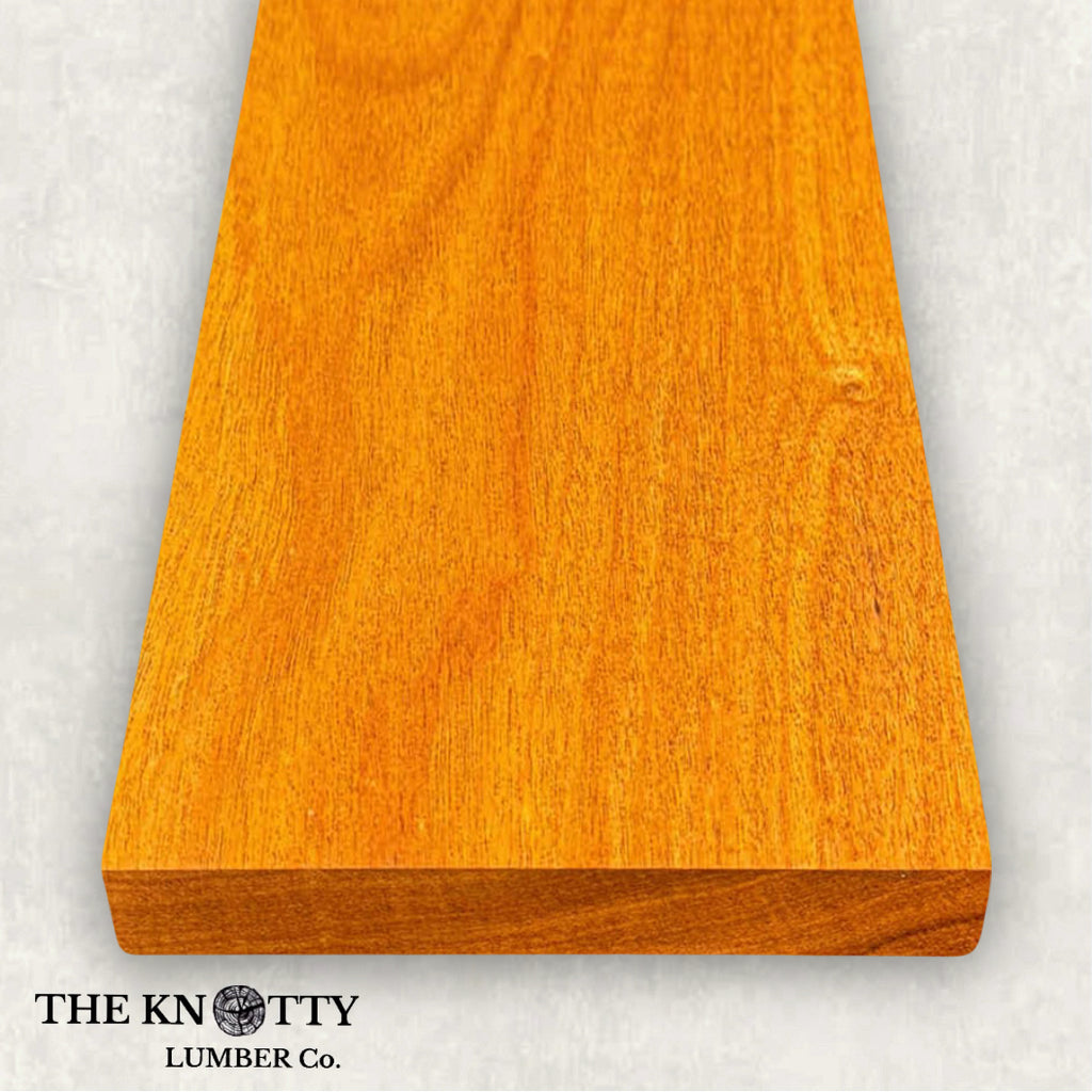 Canarywood 4/4 hardwood image. A Wooden board with the grain and with 'The Knotty Lumber Co.' logo on a light gray background