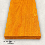 Canarywood 4/4 hardwood image. A Wooden board with the grain and with 'The Knotty Lumber Co.' logo on a light gray background
