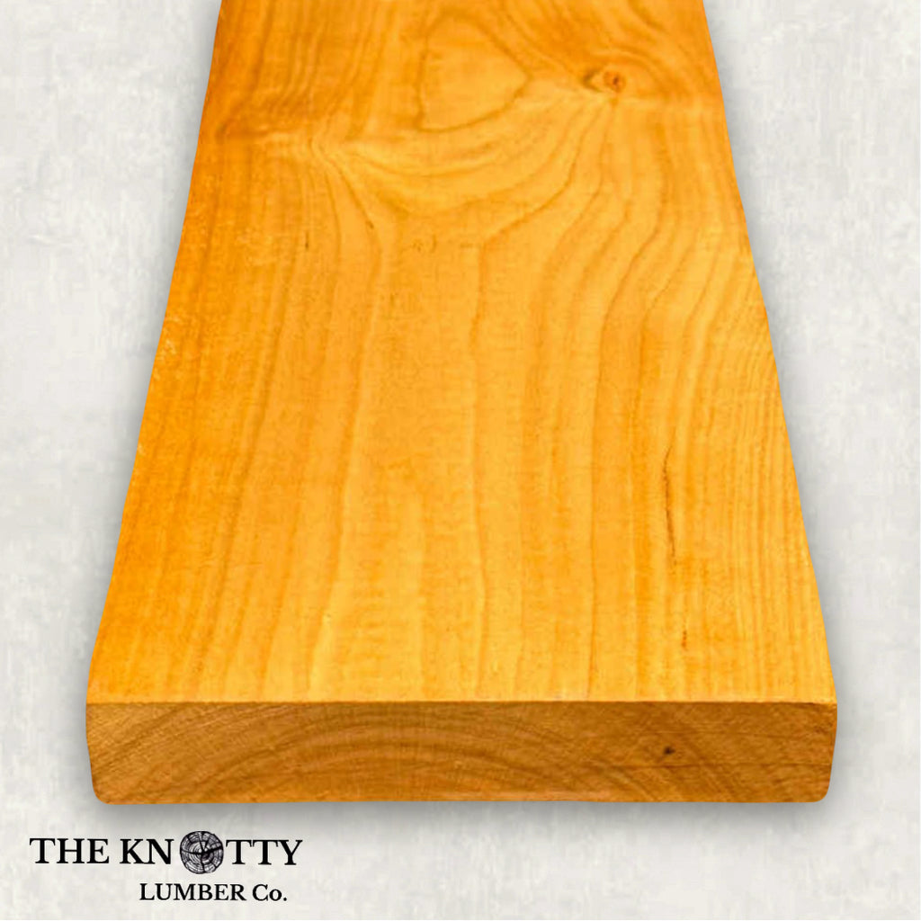 Cherry wood 4/4, A Wooden board with the grain and with 'The Knotty Lumber Co.' logo on a light grey background