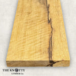 Figured Black Limba 4/4, A Wooden board with the grain and with 'The Knotty Lumber Co.' logo on a light grey background