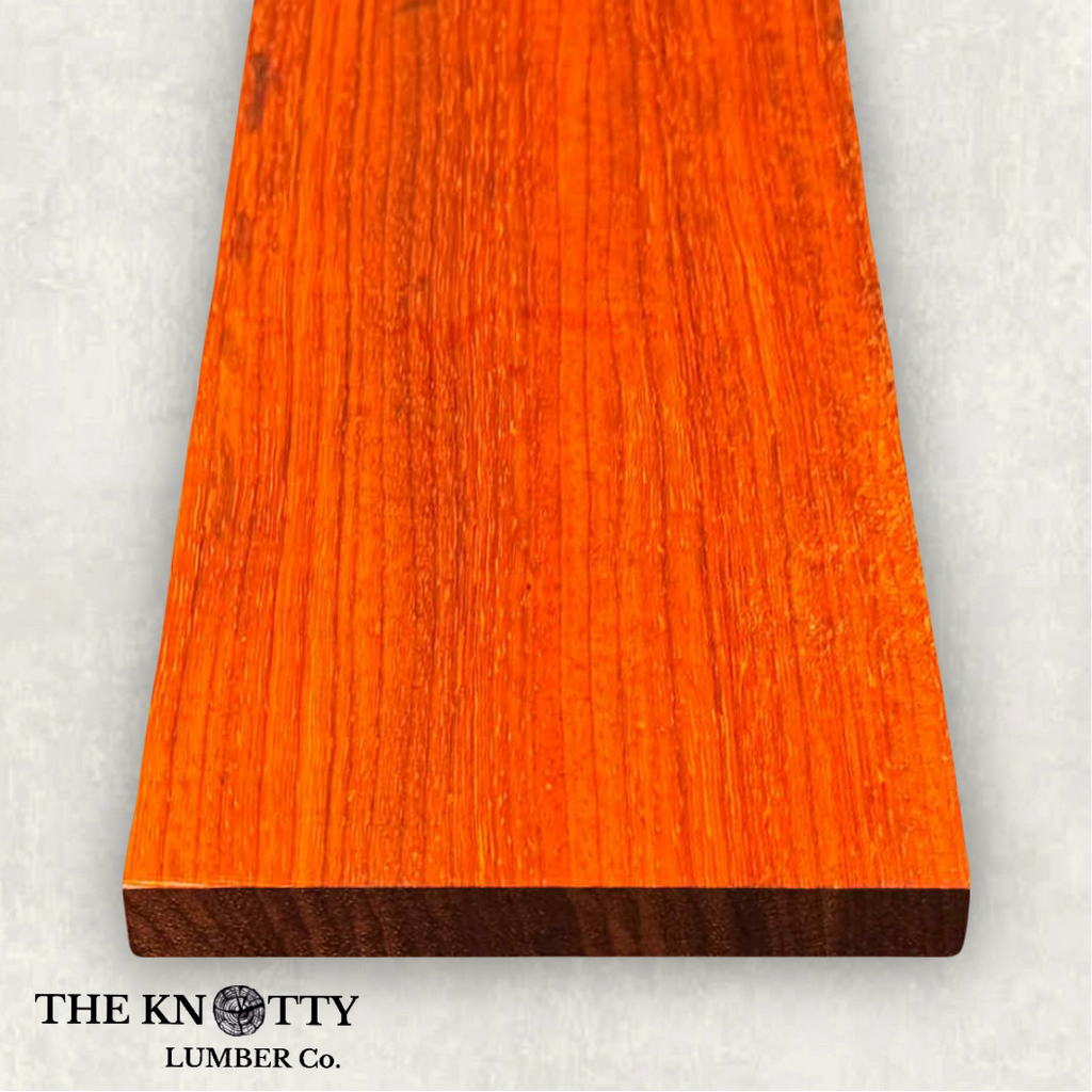 Padauk 4/4, A Wooden board with the grain and with 'The Knotty Lumber Co.' logo on a light grey background