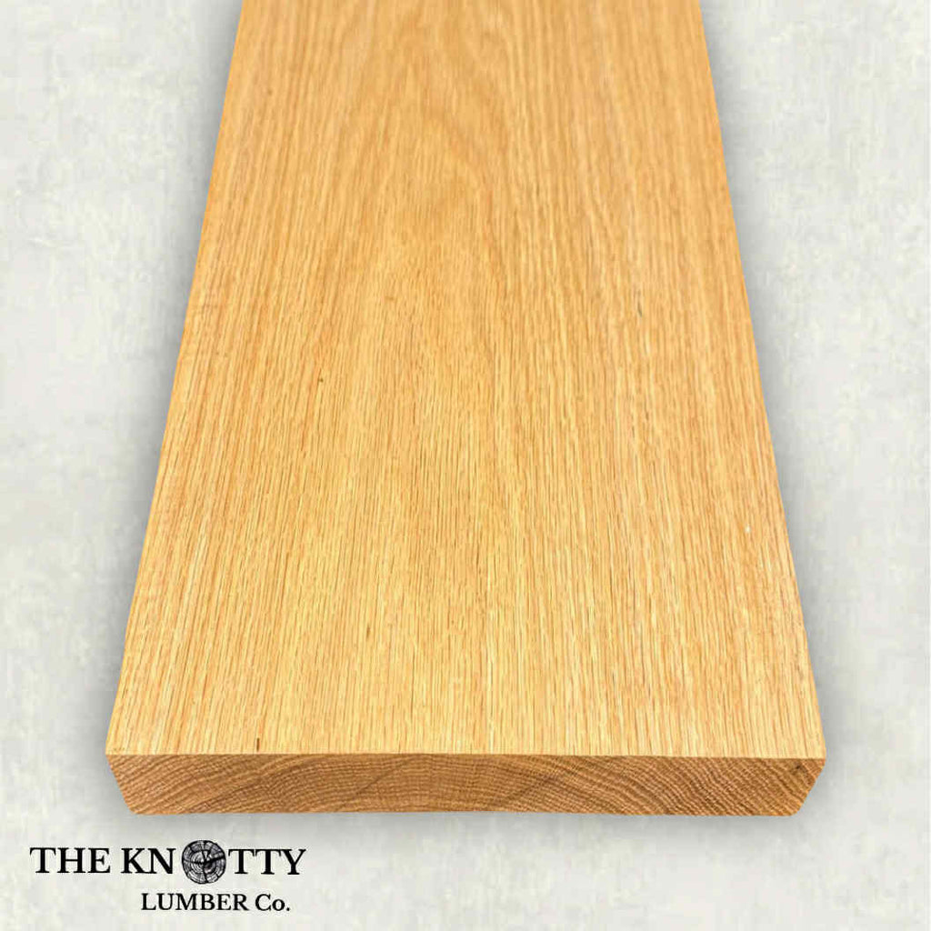 Red oak wood board with visible grain patterns on a grey background. branded with 'The Knotty Lumber Co'