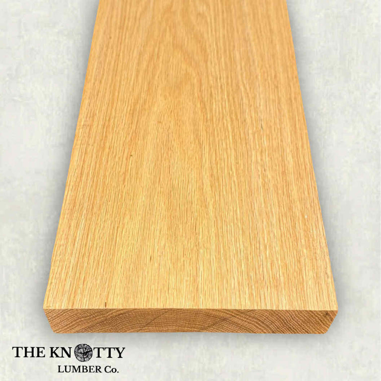 Red oak wood board with visible grain patterns on a grey background. branded with 'The Knotty Lumber Co'