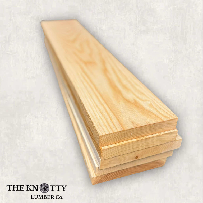 A lumber pack of beige-colored ash wood with visible wood grain, labeled with The Knotty Lumber Co.